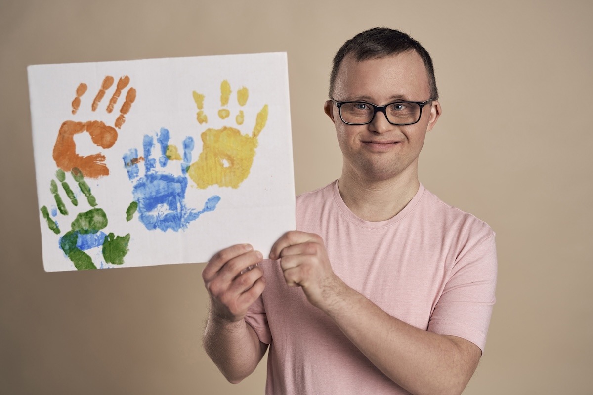 man-with-down-syndrome-showing-handprint-colorful-2024-12-04-12-23-52-utc copy